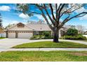 Single-story home featuring a spacious driveway, a two-car garage, and well-maintained landscaping at 16908 Equestrian Trl, Odessa, FL 33556