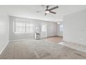 A spacious living room with a ceiling fan, carpet, and an abundance of natural light at 1901 Andover Way # 32, Sun City Center, FL 33573