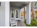 Inviting front porch features a cozy bench, attractive brick pavers, and lush tropical landscaping at 192 Haven Beach Dr, Indian Rocks Beach, FL 33785