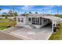 Single-story home with a screened porch, carport, and brick-paver driveway at 206 S Port Royal Ln, Apollo Beach, FL 33572