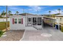 Single-story home featuring a screened porch, carport, brick-paver driveway and light gray exterior at 206 S Port Royal Ln, Apollo Beach, FL 33572