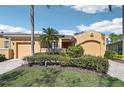 Exterior elevation shows a single-story home with a two-car garage, tidy landscaping, and a paver driveway at 2471 Kensington Greens Dr, Sun City Center, FL 33573