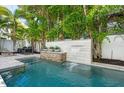 Inviting private pool featuring a waterfall feature and lush tropical landscaping at 2810 W Alline Ave, Tampa, FL 33611