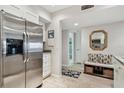 Bright kitchen with stainless steel refrigerator, bench seating and doorway to bathroom at 301 Mariner Dr # 301, Tarpon Springs, FL 34689