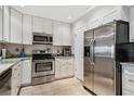 Well-lit kitchen featuring stainless steel appliances, granite countertops and tile flooring at 301 Mariner Dr # 301, Tarpon Springs, FL 34689