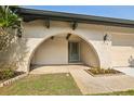 Arched front entrance with textured walls, a blue front door, and decorative plants at 3116 Swan Ln, Safety Harbor, FL 34695