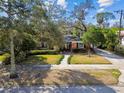 Charming brick home featuring mature landscaping, lush lawn, and a welcoming walkway to the front door at 4532 W Beachway Dr, Tampa, FL 33609