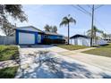 Inviting single-story home with a blue exterior, attached garage, and a well-manicured front yard at 4570 69Th N Ave, Pinellas Park, FL 33781