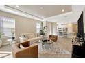 Bright living room featuring a tray ceiling, neutral décor, and seamless open floor plan at 4576 Garofalo Rd, Wesley Chapel, FL 33543