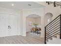 Bright entryway with double doors, hardwood floors, and view of dining area at 5226 Golf Links Blvd, Zephyrhills, FL 33541