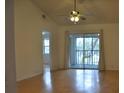 Living room with vaulted ceiling, wood floors, and sliding glass doors at 5265 E Bay Dr # 323, Clearwater, FL 33764