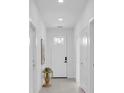 Bright entryway featuring white walls, a white front door, and light wood-look flooring at 5331 71St N Way, St Petersburg, FL 33709