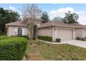 Tan house with a two-car garage and neatly trimmed landscaping at 6538 Green Acres Blvd, New Port Richey, FL 34655