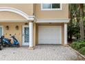 Close-up of a townhouse showing the garage, front door with columns, and paved driveway at 684 Bayway Blvd, Clearwater, FL 33767