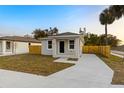 Newly built house with gray siding, a small front yard, and a concrete driveway at 701 E Wood St, Tampa, FL 33604