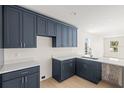 Modern kitchen with dark blue cabinetry, white countertops, and a kitchen island at 701 E Wood St, Tampa, FL 33604