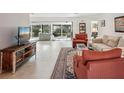 Bright living room featuring neutral tile flooring, comfortable seating, and a view of the outdoors at 7161 Fairway Bend Cir, Sarasota, FL 34243