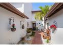 Charming courtyard entrance with brick pathway, lush plants, and decorative wall art leading to a welcoming front door at 7501 Cumberland Rd # 22, Seminole, FL 33777