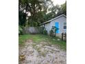 Side view showing gray house, yard, and fence at 8004 N 11Th St, Tampa, FL 33604