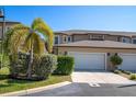 View of the exterior features including a two car garage, desert landscaping and neutral color palette at 868 Date Palm Ln, St Petersburg, FL 33707