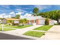 Light coral house with a white garage door and palm trees at 8807 Oak Cir, Tampa, FL 33615