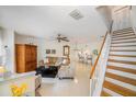 Living room with tiled floor, couch, and wooden staircase at 949 Hamilton Ct, Palm Harbor, FL 34683