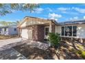 A single-story home featuring a two-car garage and a stone-accented facade at 10201 127Th Pl, Largo, FL 33773