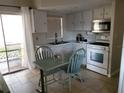 Cozy kitchen with white cabinets, appliances, a breakfast nook, and sliding glass doors to the outside at 12400 Park Blvd # 417, Seminole, FL 33772