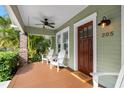 Cozy front porch featuring a stained wood floor, ceiling fan, and welcoming seating at 205 W North St, Tampa, FL 33604