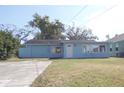 Charming blue single-story home featuring a well-maintained lawn and a concrete driveway at 205 Washington Ave, Oldsmar, FL 34677