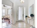 Bright foyer with tile flooring, white walls, and a decorative table creating a welcoming entrance to the home at 3647 Fawnmist Dr Dr, Wesley Chapel, FL 33544