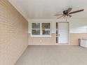 Covered front porch with brick walls, ceiling fan, and carpet flooring at 5152 Victoria Ln, Holiday, FL 34690