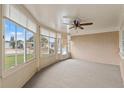 Bright sunroom with multiple windows, carpet flooring and a ceiling fan at 5152 Victoria Ln, Holiday, FL 34690