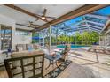 Relaxing covered patio with comfortable seating, ceiling fans, and views of the screened in pool area at 5501 E Longboat Blvd, Tampa, FL 33615