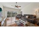 Bright living room features hardwood floors, ceiling fan, and sliding doors to a balcony at 7532 Marsh Orchid Cir # 8-201, Bradenton, FL 34203