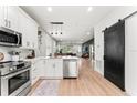 Open concept kitchen with white cabinets, island, and view into living area at 8723 N Calder Pl, Tampa, FL 33604