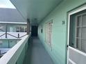 Exterior hallway with a light green wall and a number of apartment doors at 2042 Australia W Way # 74, Clearwater, FL 33763