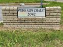 Brick sign displaying the name 'Swiss Alps Chalet 2042' at the property entrance at 2042 Australia W Way # 74, Clearwater, FL 33763