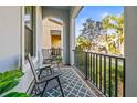 Cozy porch with chairs, table, decorative rug, and wrought iron railing with neighborhood views at 1021 Seagrape Dr, Ruskin, FL 33570