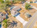 An aerial view of the property shows a pool with a screened enclosure, as well as the driveway and surrounding landscape at 10261 Horizon Dr, Spring Hill, FL 34608