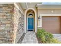 Front entrance with teal door and stone walkway at 1045 Tracey Ann Loop, Seffner, FL 33584