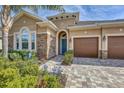 House exterior with stone accents, teal door, and landscaped walkway at 1045 Tracey Ann Loop, Seffner, FL 33584