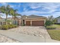 Two-story house with brown doors, paver driveway, and landscaped yard at 1045 Tracey Ann Loop, Seffner, FL 33584