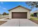 Tan house with brown garage door, front yard, and walkway at 11206 Silver Fern Way, Riverview, FL 33569