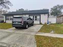 View of the home showing a paved driveway and functional backyard space at 12368 70Th St, Largo, FL 33773