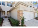 Stylish townhome exterior with a two-car garage and stone accents at 14543 Mirabelle Vista Cir, Tampa, FL 33626