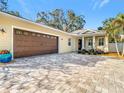 Wide driveway and attached garage of a charming, light-yellow single Gathering home at 415 5Th N St, Safety Harbor, FL 34695