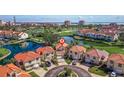 Aerial view of red-roofed homes on a manicured golf course with serene ponds and waterfront cityscape backdrop at 6105 Mirada Cir, St Petersburg, FL 33715
