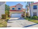 Charming two-story home with a well-kept lawn, featuring a two-car garage and a red-tiled roof at 6105 Mirada Cir, St Petersburg, FL 33715