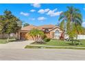 Beautiful single Gathering home with a well-manicured lawn, mature trees, and a two-car garage on a sunny day at 6426 Gondola Dr, Riverview, FL 33578